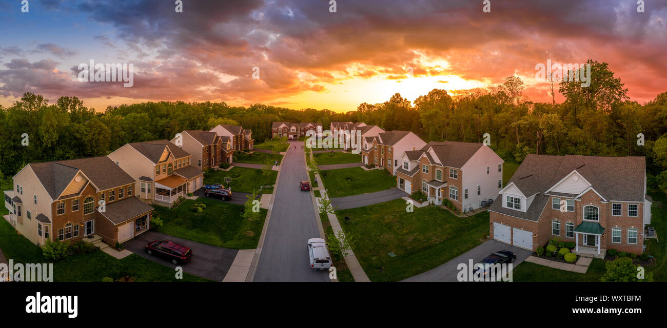 American luxury real estate single family houses with brick facade, solar power roof new construction Maryland street neighborhood with sunset Stock Photo