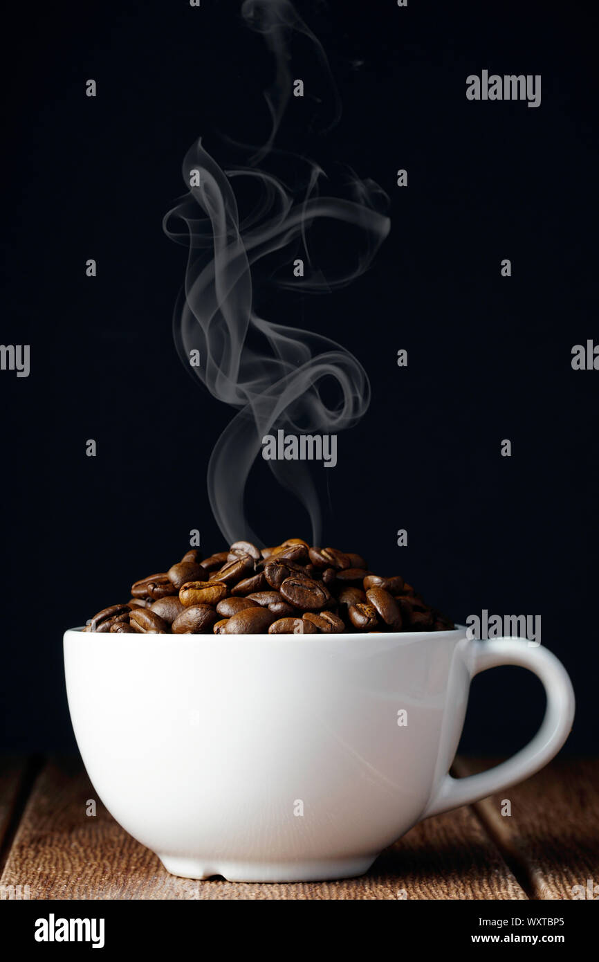 coffee beans in a white cup over black background. International Coffee Day Stock Photo