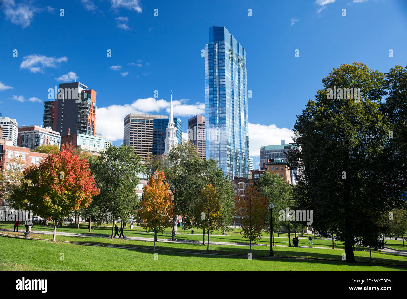 People strolling in Boston Common by the Public Garden city park and skyscrapers in Boston, Massachusetts, USA Stock Photo