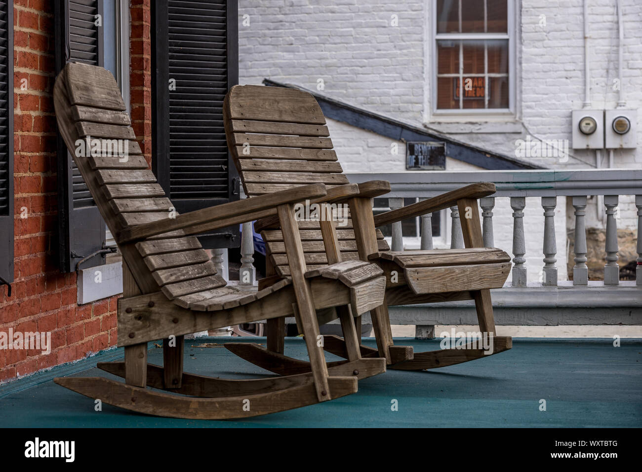 Wooden rocking chairs on a colonial porch somewhere in America Stock Photo