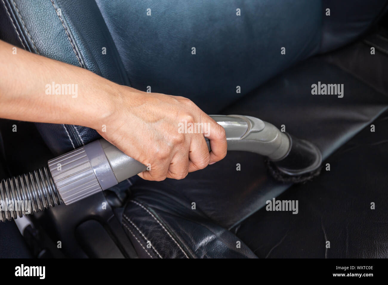 Cleaning modern car interior with vacuum cleaner. Handle vacuum Stock