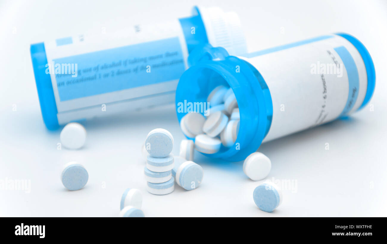 Paracetamol in blue and white plain compress tablets with caution on the  bottle Stock Photo - Alamy