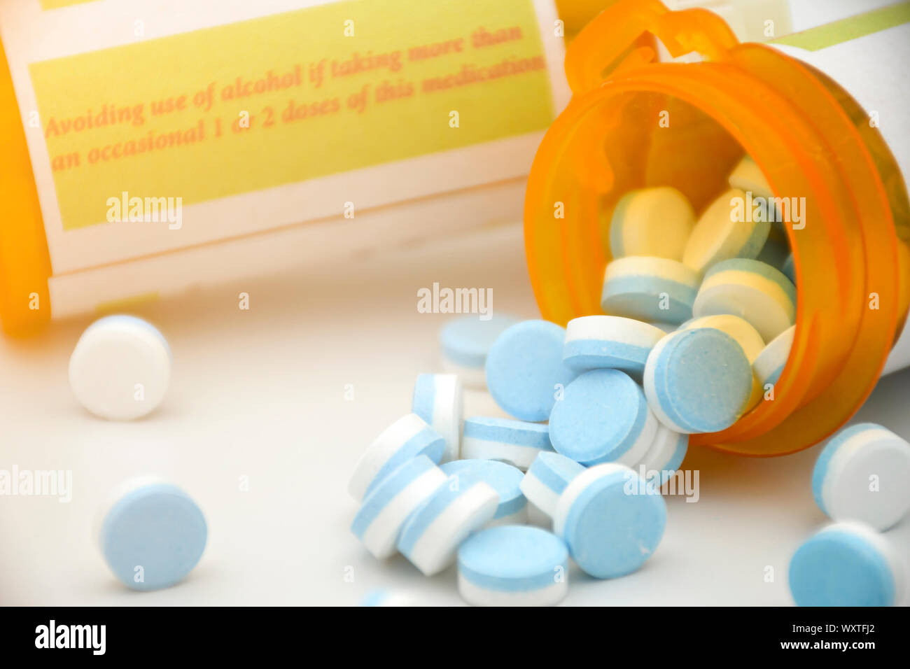 Paracetamol in blue and white plain compress tablets with caution on the bottle. Stock Photo