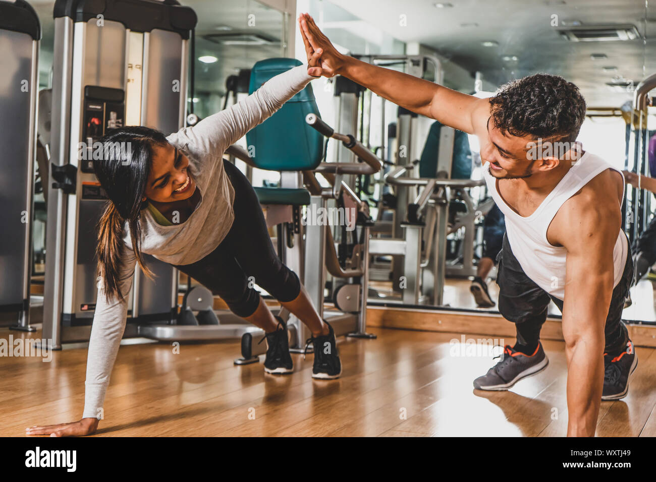 Couple training at gym, high five during pushups Stock Photo - Alamy
