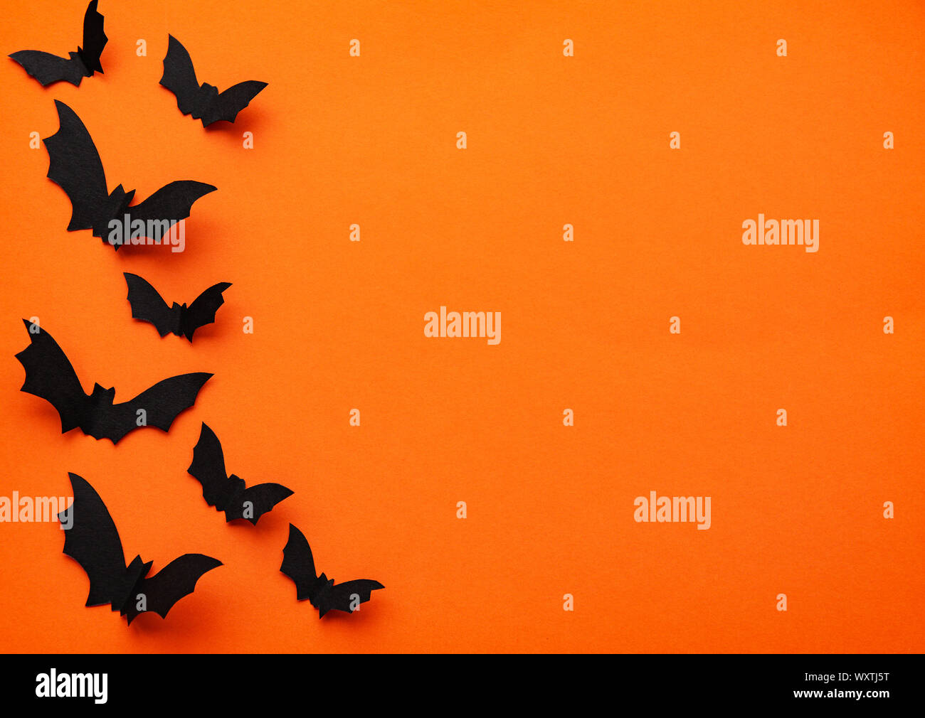 halloween concept - black paper bats flying over orange background ...