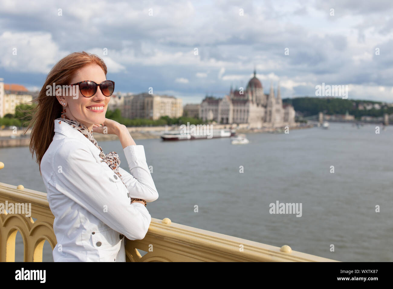 Happy young brunette woman toothy smiling at autumn Budapest panorama Stock Photo