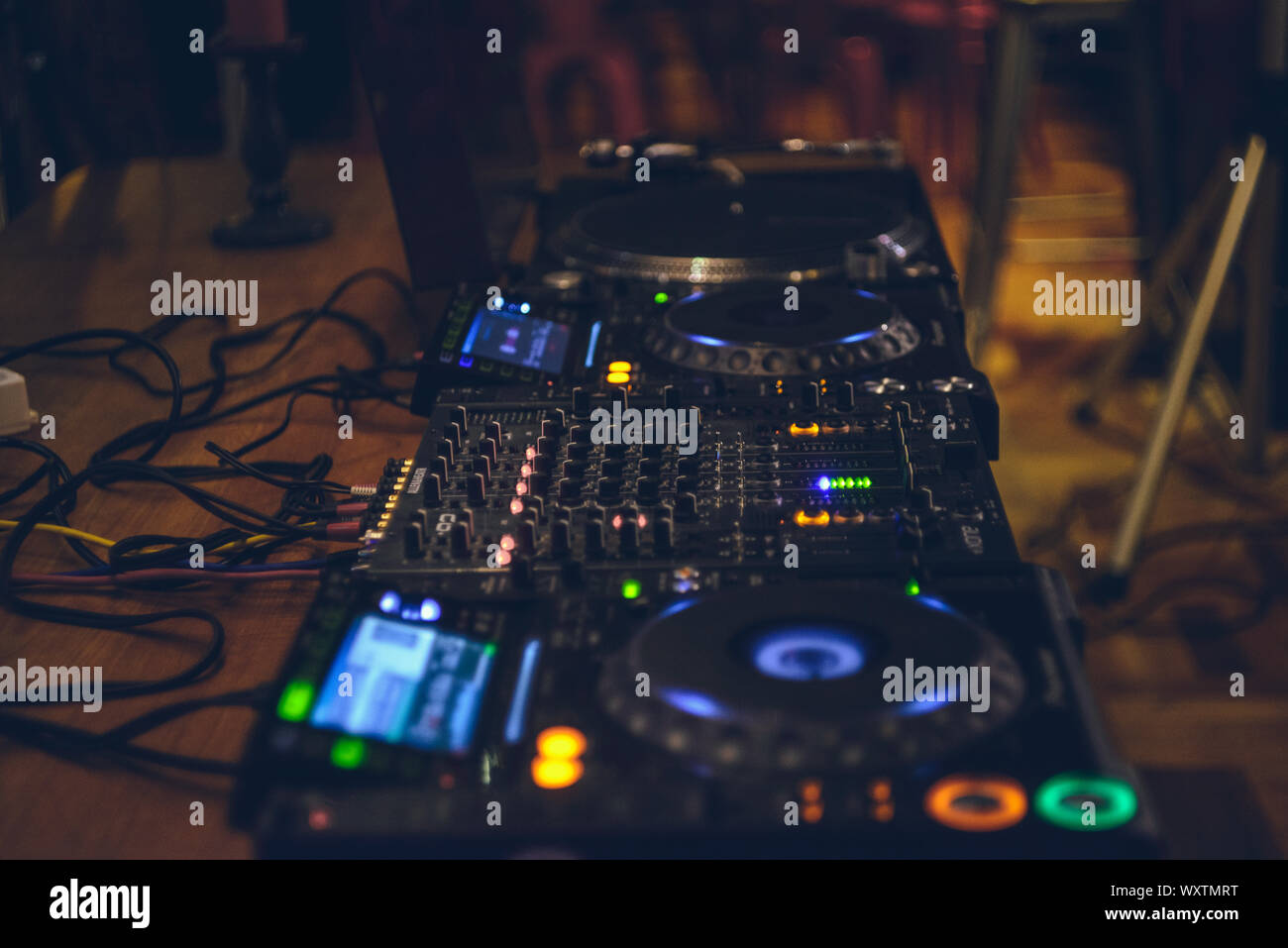 DJ CD player and mixer. DJ Spinning, Mixing, and Scratching in a Night  Club, Hands of dj tweak various track controls on dj's deck, strobe lights  and Stock Photo - Alamy
