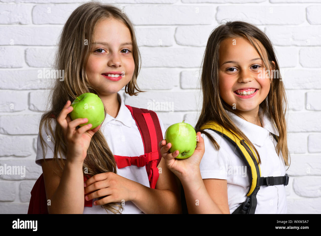 happy girls eating fresh green apple at school Stock Photo - Alamy