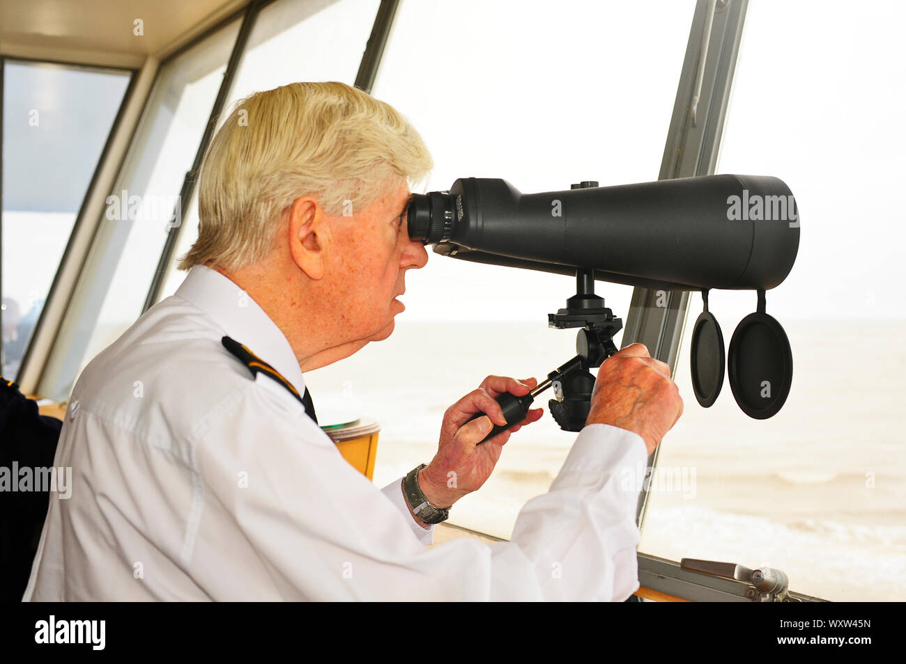 Member of National Coastwatch Institution looking out to sea from Rossall Point observation tower,Fleetwood Stock Photo