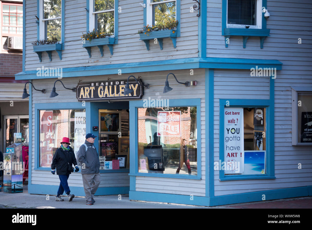 People strolling past wood clapboard Seaside Art Gallery in typical