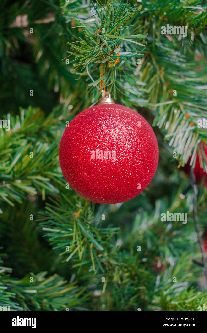 Red Christmas tree ball decoration, with green tree background Stock ...
