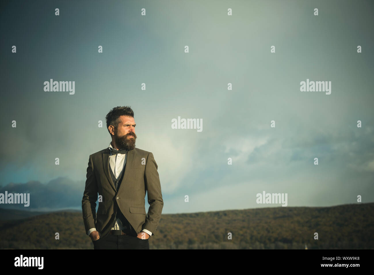 Hipster with beard and mustache on unshaven face. Bearded man on cloudy ...