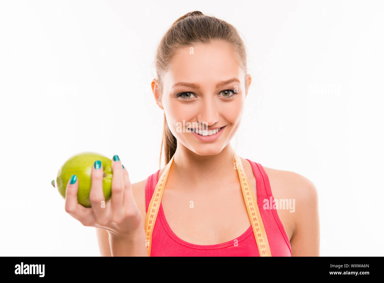 Pretty sporty girl with green apple in her hand Stock Photo - Alamy
