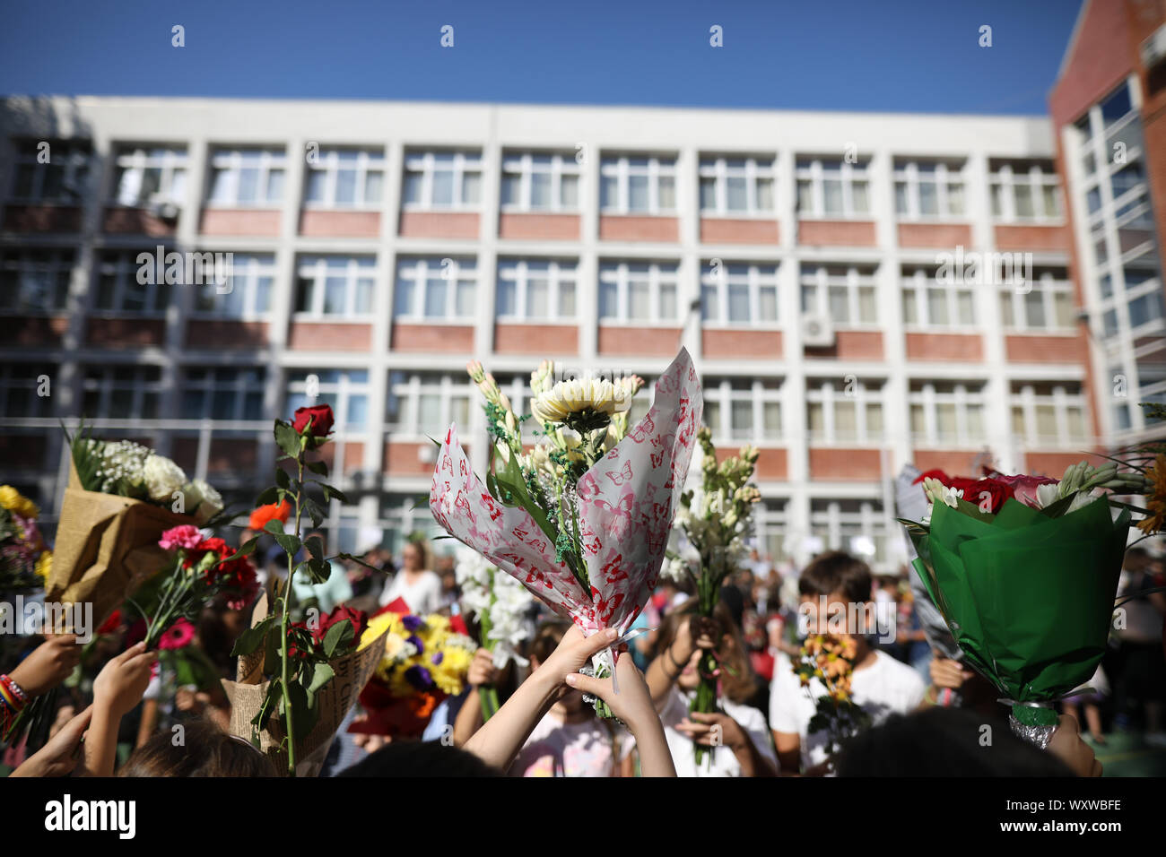 Children hold flowers in their first day of school Stock Photo