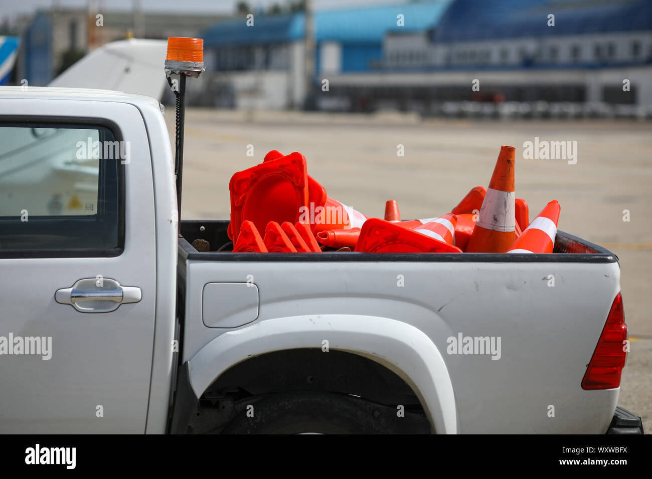 Details with the back of a truck carrying orange traffic safety cones on the runway of an airport Stock Photo