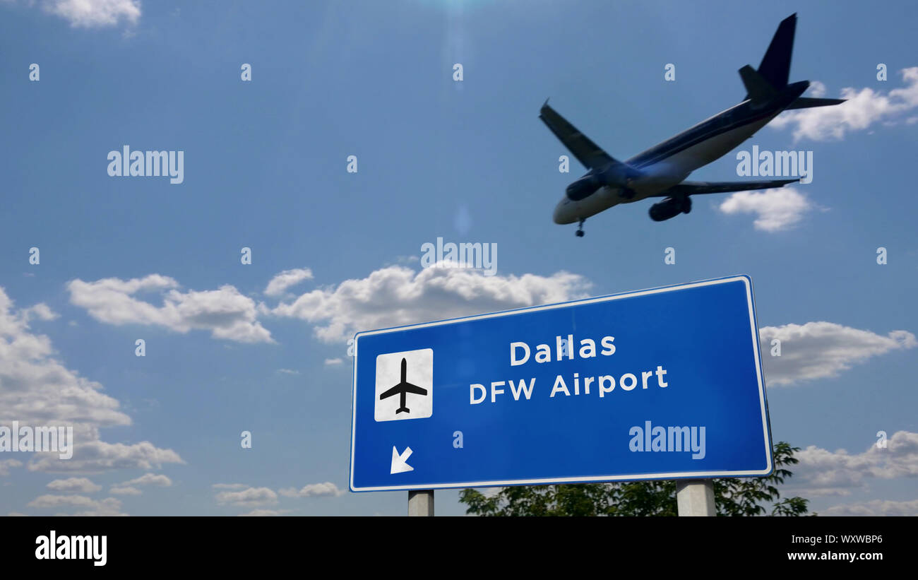 Airplane silhouette landing in Dallas DFW, Texas, USA, America. City arrival with international airport direction signboard and sky in background. Tra Stock Photo