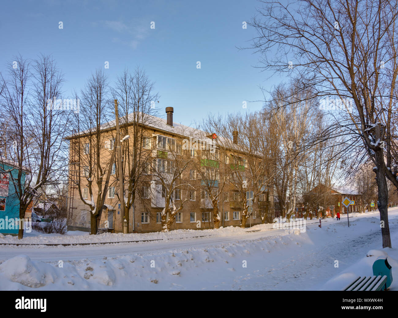 4-storey building made of silicate brick on a snowy street in a provincial village. Stock Photo