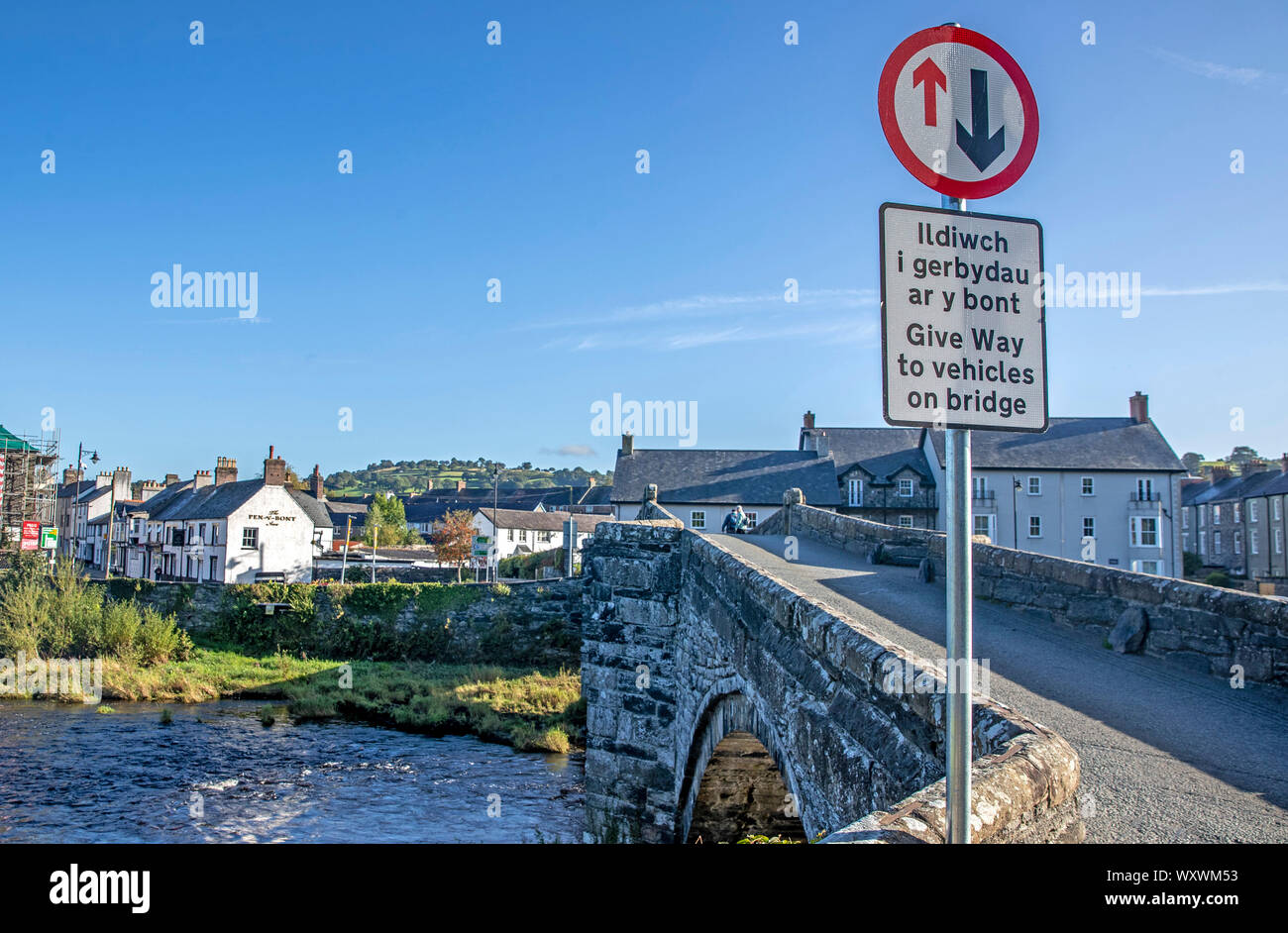A sign post on the narrow bridge beside the Tu Hwnt l'r Bont Tearoom on the banks of the River Conwy in Llanrwst, north Wales. One of the UK's most scenic views has been ruined with the installation of a new road sign warning drivers to give way across a narrow bridge. Stock Photo