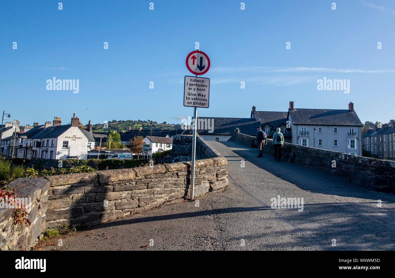 A sign post on the narrow bridge beside the Tu Hwnt l'r Bont Tearoom on the banks of the River Conwy in Llanrwst, north Wales. One of the UK's most scenic views has been ruined with the installation of a new road sign warning drivers to give way across a narrow bridge. Stock Photo