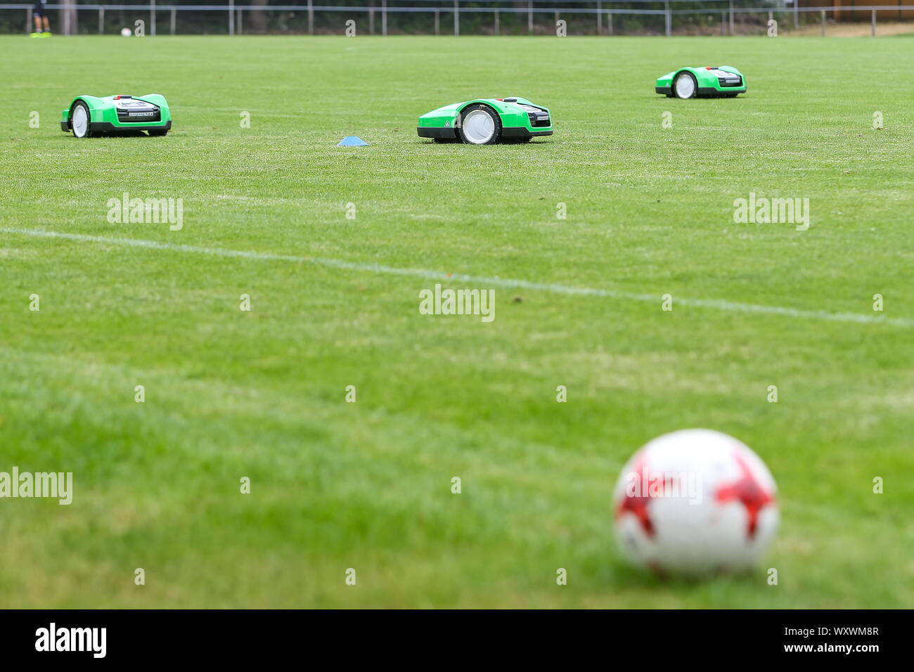 Oosterbeek, Netherlands - July 11, 2018: Automatic robotic lawnmower on green grass in the stadium. Mowing the lawn with a robot. Stock Photo