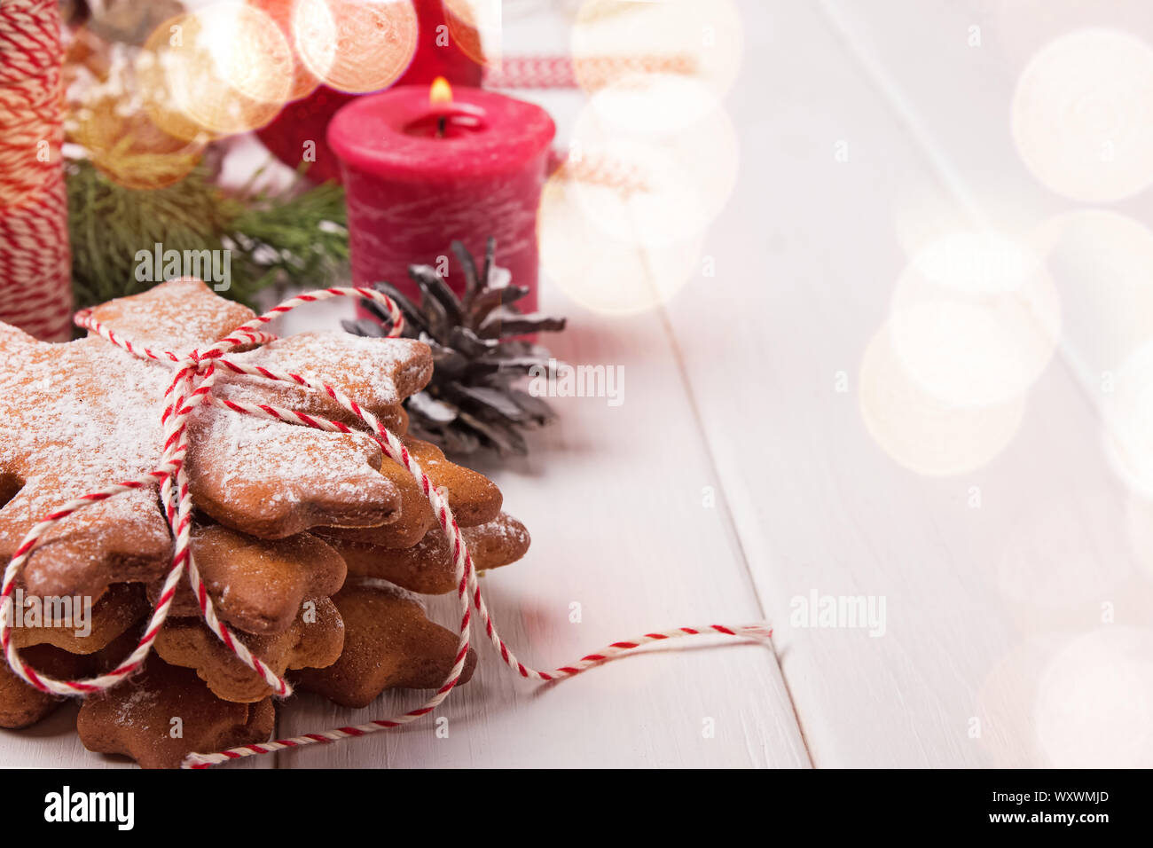 Stack of snowflake shaped cookies powdered with icing sugar close-up on the table with Christmas decor Stock Photo
