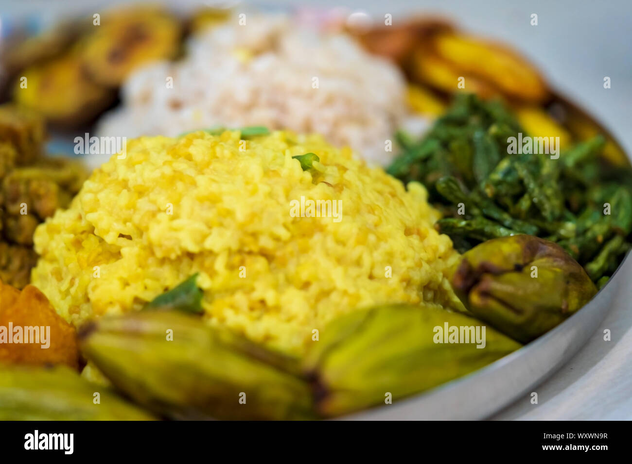 Closeup shot of a festive food thali full of traditional bengali dishes khichdi, pulao, curry, payesh & various other homemade cooking background. Stock Photo