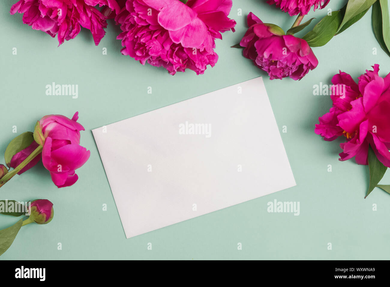 Paper card mock-up on the table with beautiful peonies Stock Photo