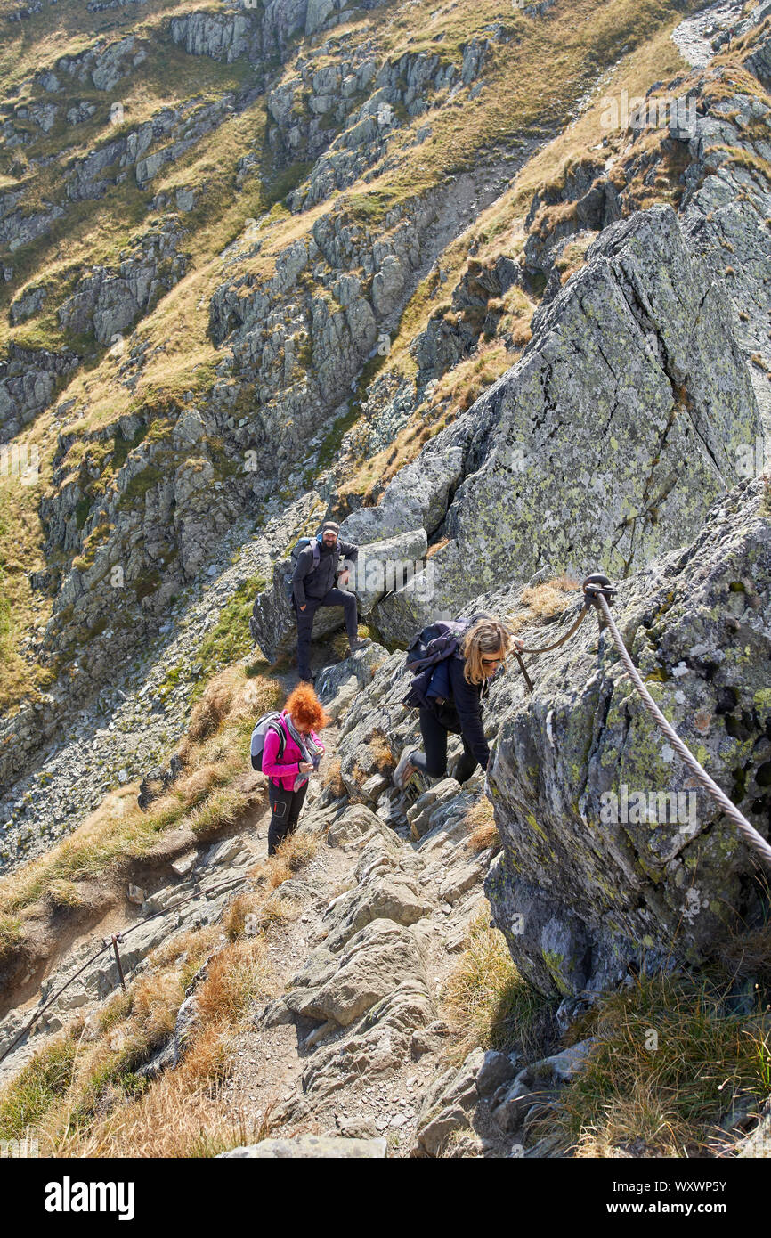 Two women with backpacks hiking on a mountain trail Stock Photo - Alamy