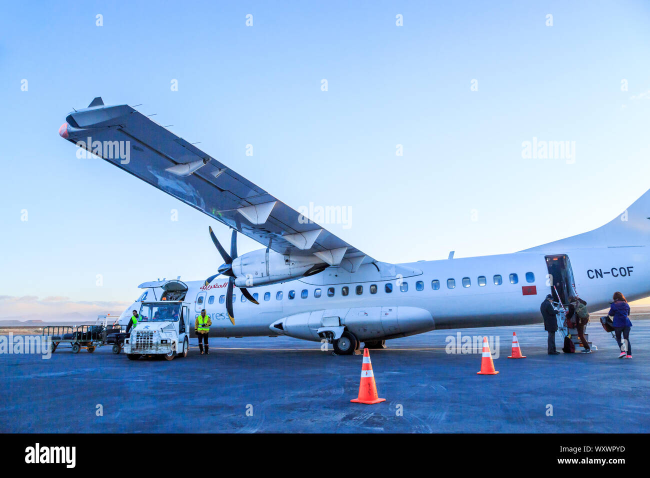 Ouarzazate, Morocco - Feb 28, 2016: agents of the airline charges passengers' luggages in the hold of the airliner while the passengers ride through t Stock Photo