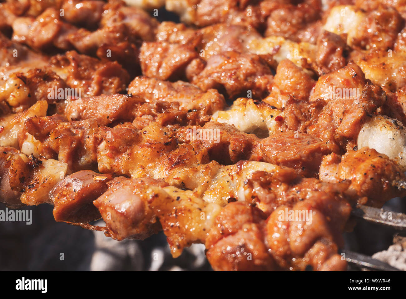 Grilling marinated shashlik on a grill. Shashlik is a form of Shish kebab  popular in Eastern, Central Europe and other places. Shashlyk meaning skewer  Stock Photo - Alamy