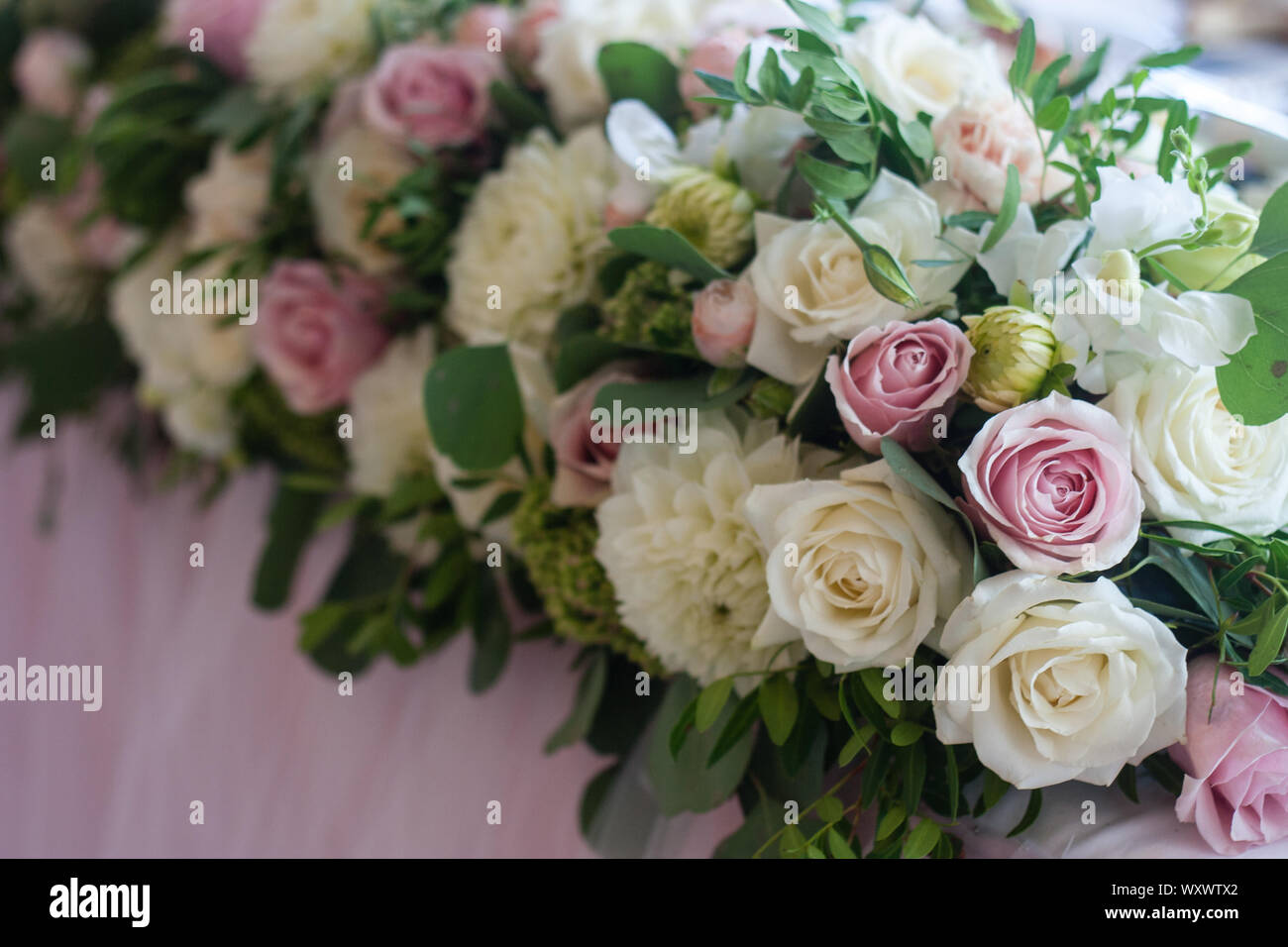 Wedding table decoration with pink and white tender roses. Floral decorations design. Selective focus. Stock Photo