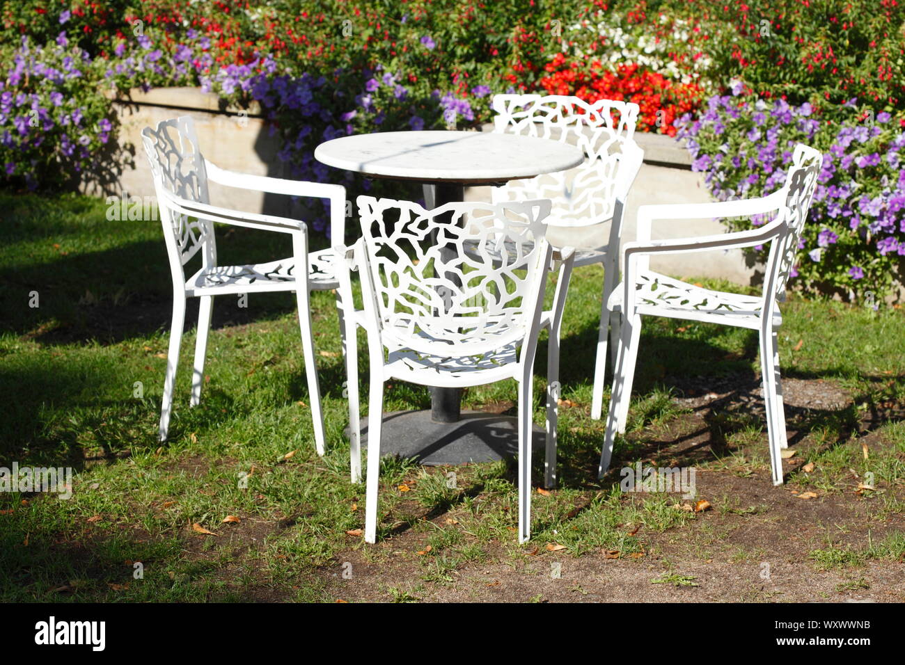 White plastic chairs and plastic table standing in the garden, Germany, Europe Stock Photo
