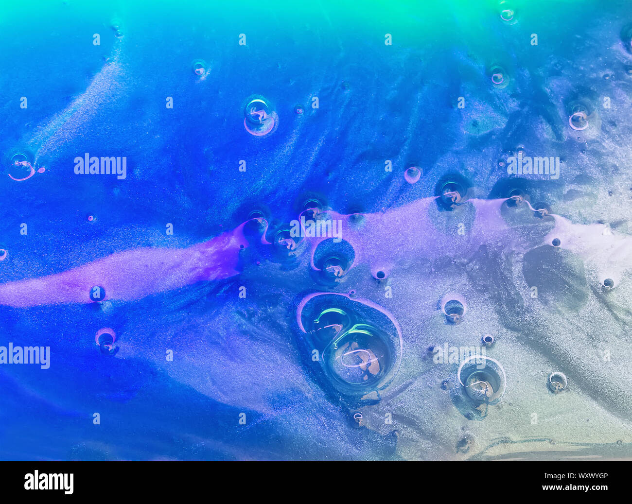 Texture of slime or other liquid substance lighted with purple and ...