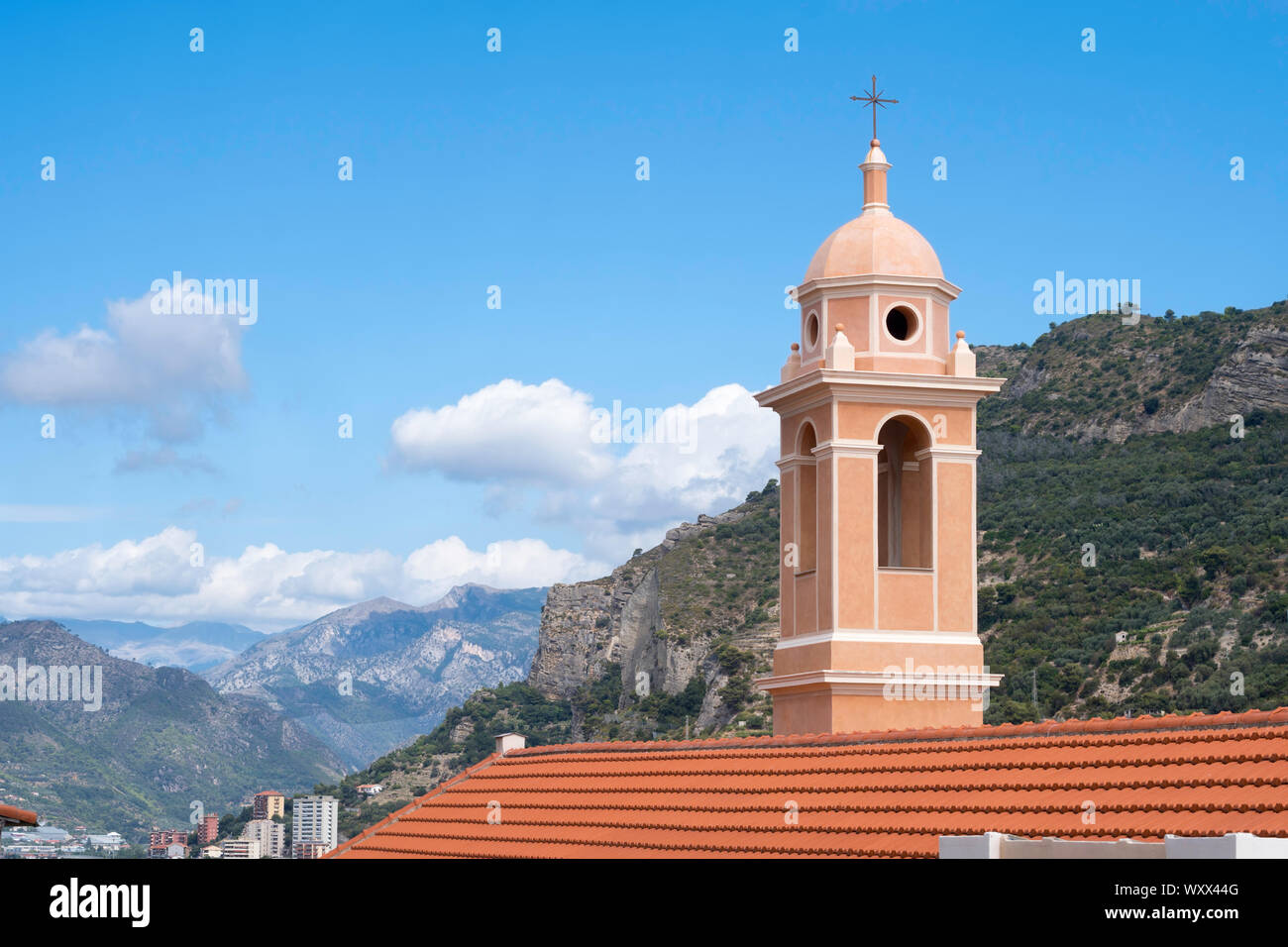 The bell tower of the church of Santa Marta in Ventimiglia with a mountainous landscape behind, Liguria, Italy, Europe Stock Photo