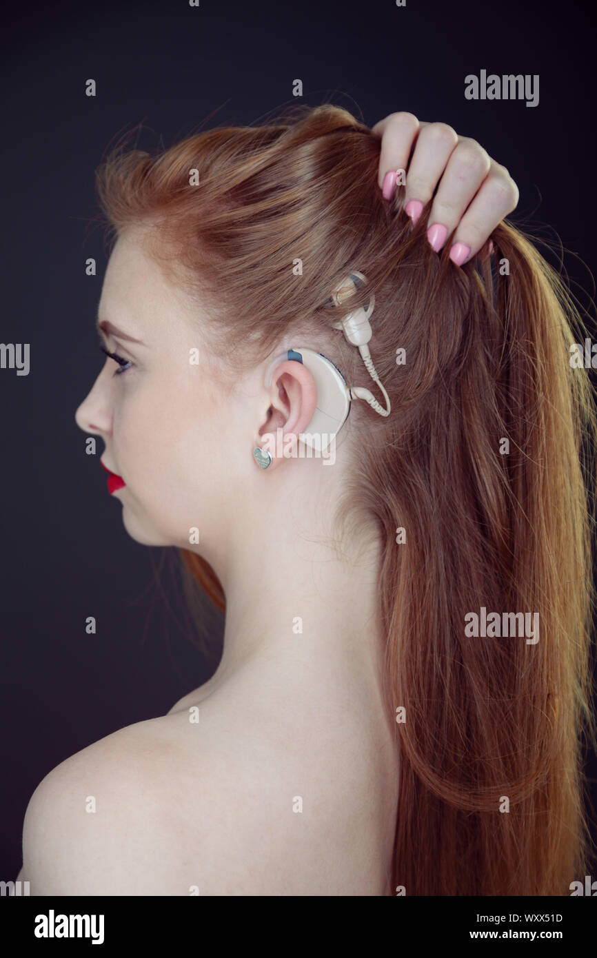A portrait of a beautiful young woman who has a cochlear implant. Stock Photo