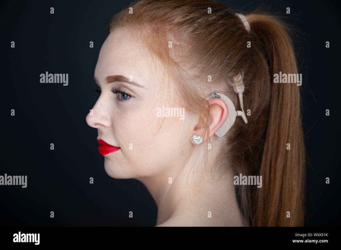 A portrait of a beautiful young woman who has a cochlear implant. Stock Photo