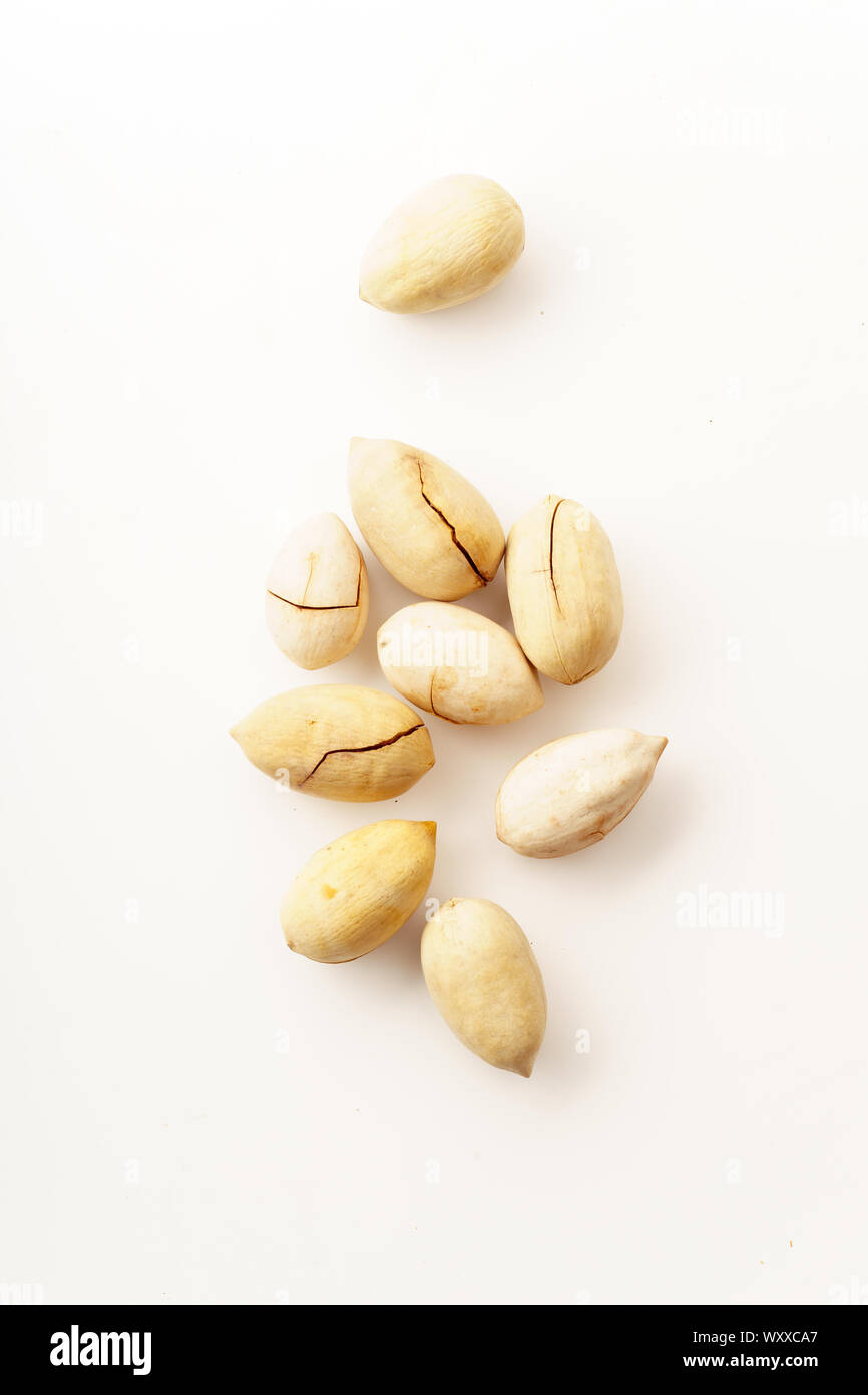 Pecan nuts in nutshells isolated. Overhead image, white background Stock Photo