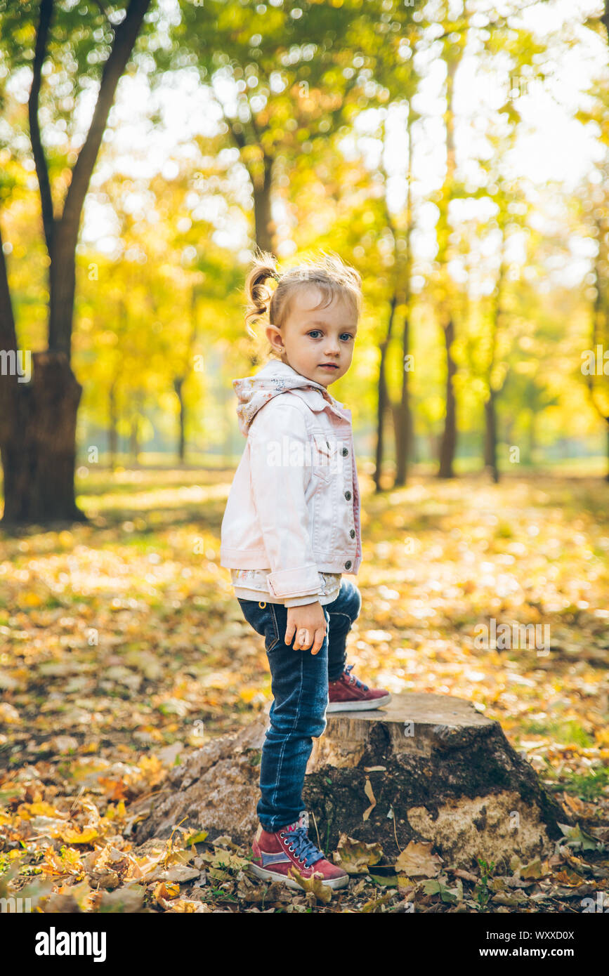 little smiling blond cute toddler girl at autumn city park Stock Photo ...