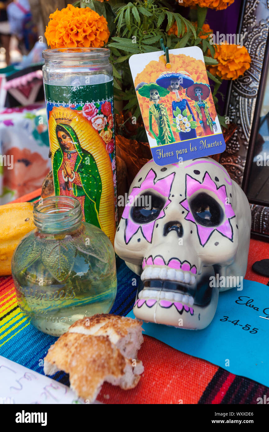 An altar featuring colourful sugar skulls / calaveras, candles, and fruit at the Dia de Los Muertos / Day of the Dead festival in Mesilla, New Mexico, Stock Photo