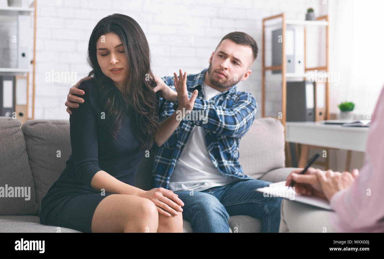 Irritated woman denying her husband's try to reconcile Stock Photo