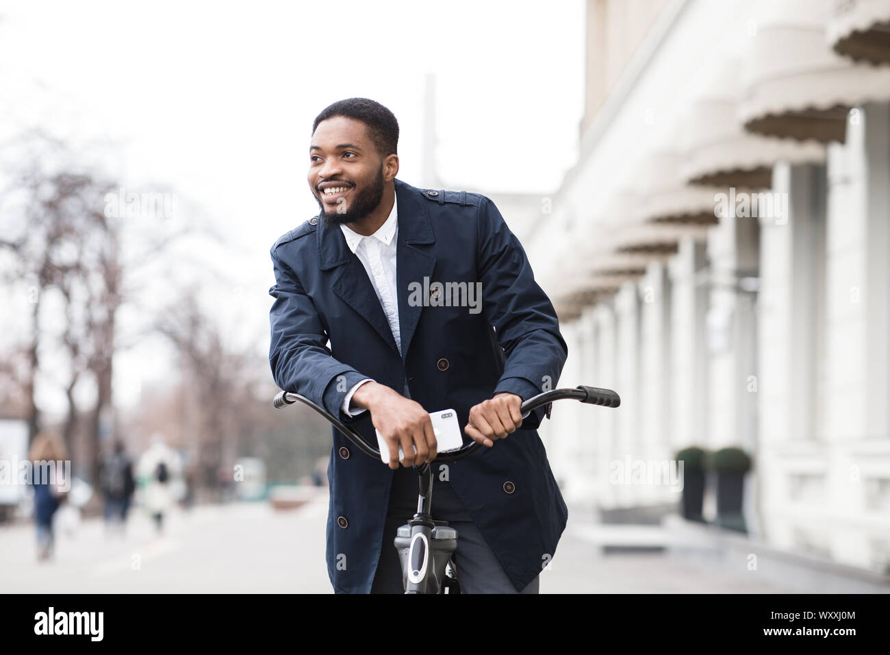 African american man in suit riding on bike to work Stock Photo