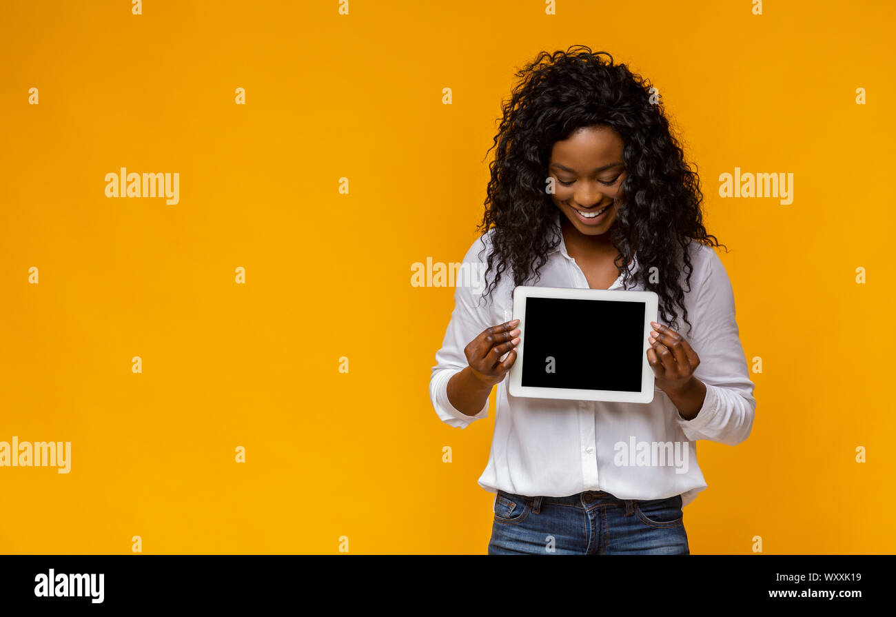 Happy afro girl demonstrating blank digital tablet screen Stock Photo ...