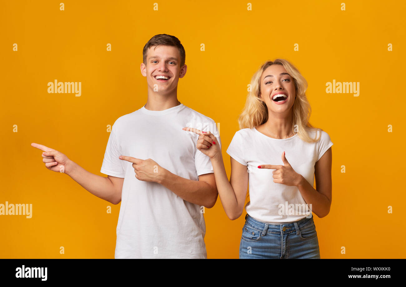 Excited young couple pointing aside at copy space Stock Photo