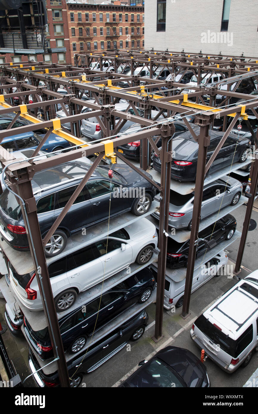 Space-saving automated stacked parking lot with hydraulic lift part of city living and overcrowding in New York City, USA Stock Photo