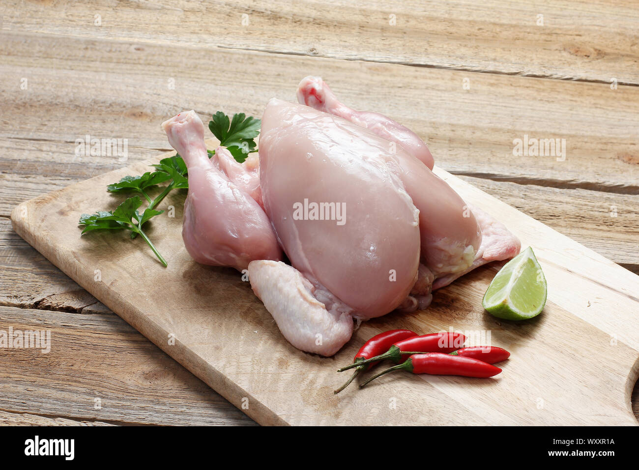 Skinless Whole Chicken on Chopping Board Stock Photo