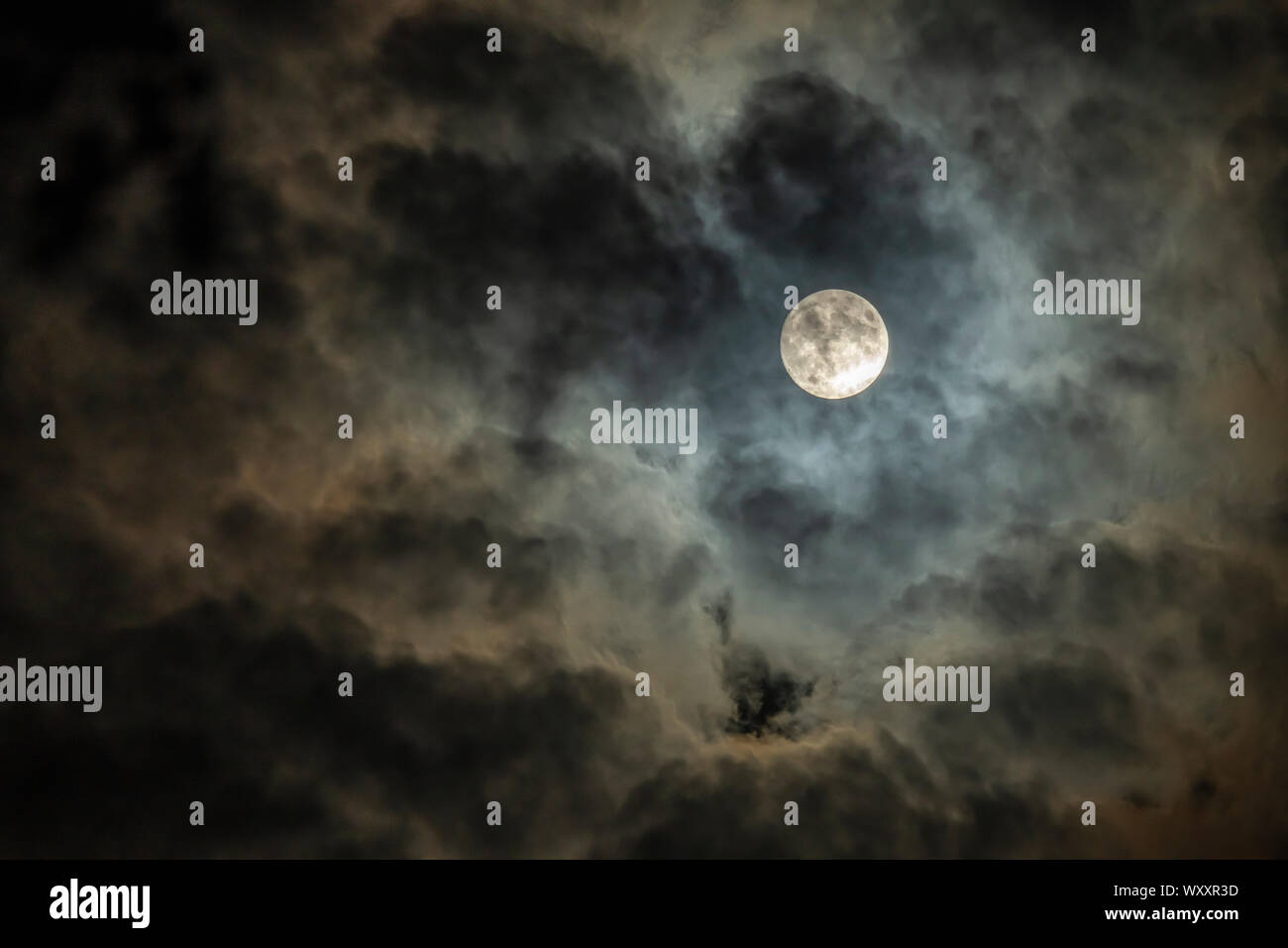 Full moon in cloudy night sky Stock Photo