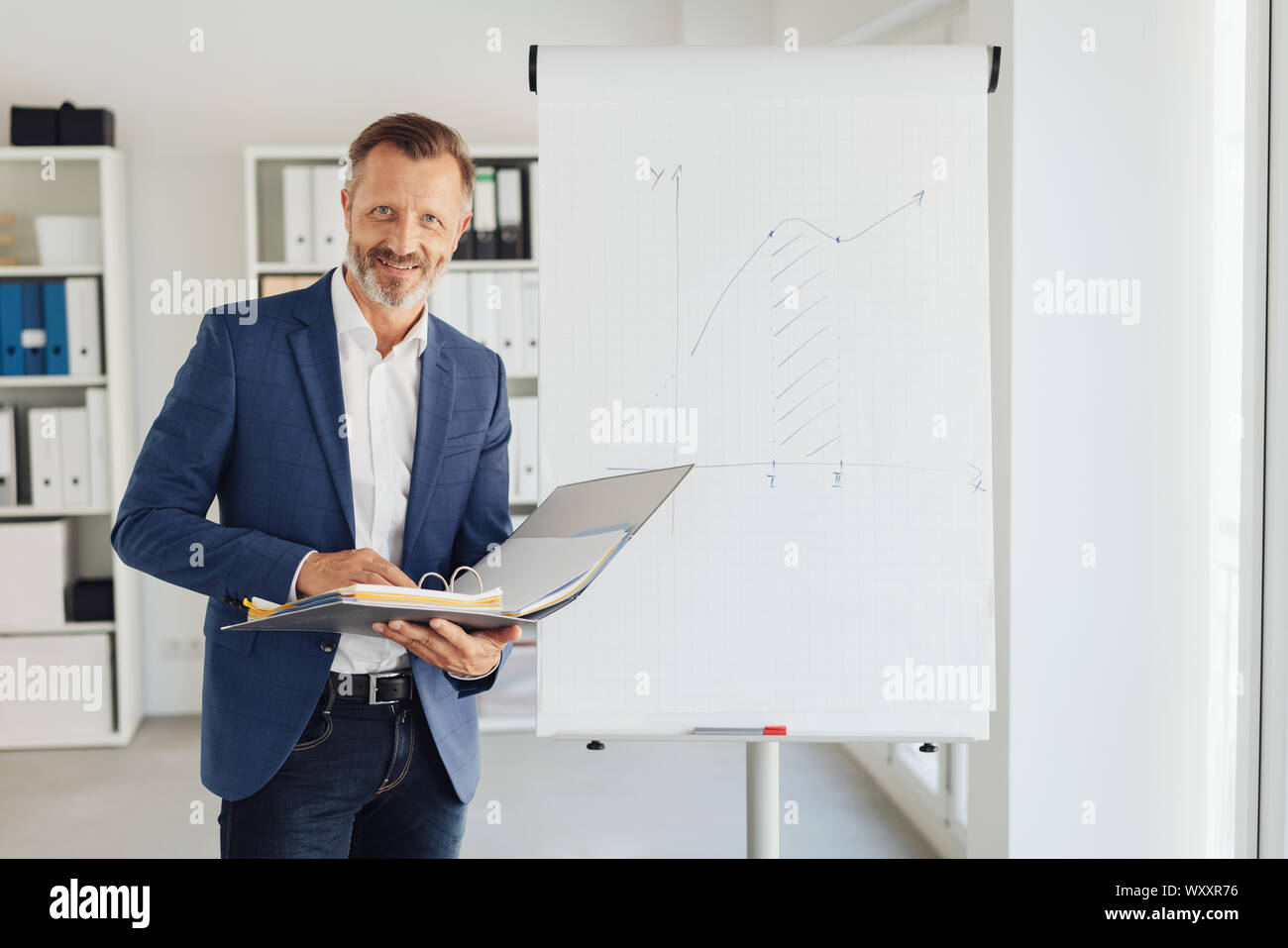 Attractive stylish businessman doing a presentation standing in front