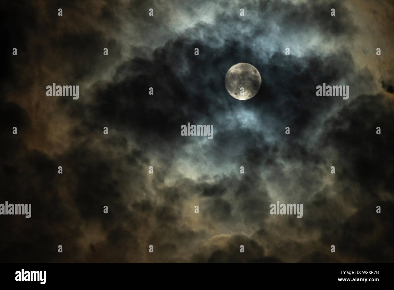 Full moon in cloudy night sky Stock Photo