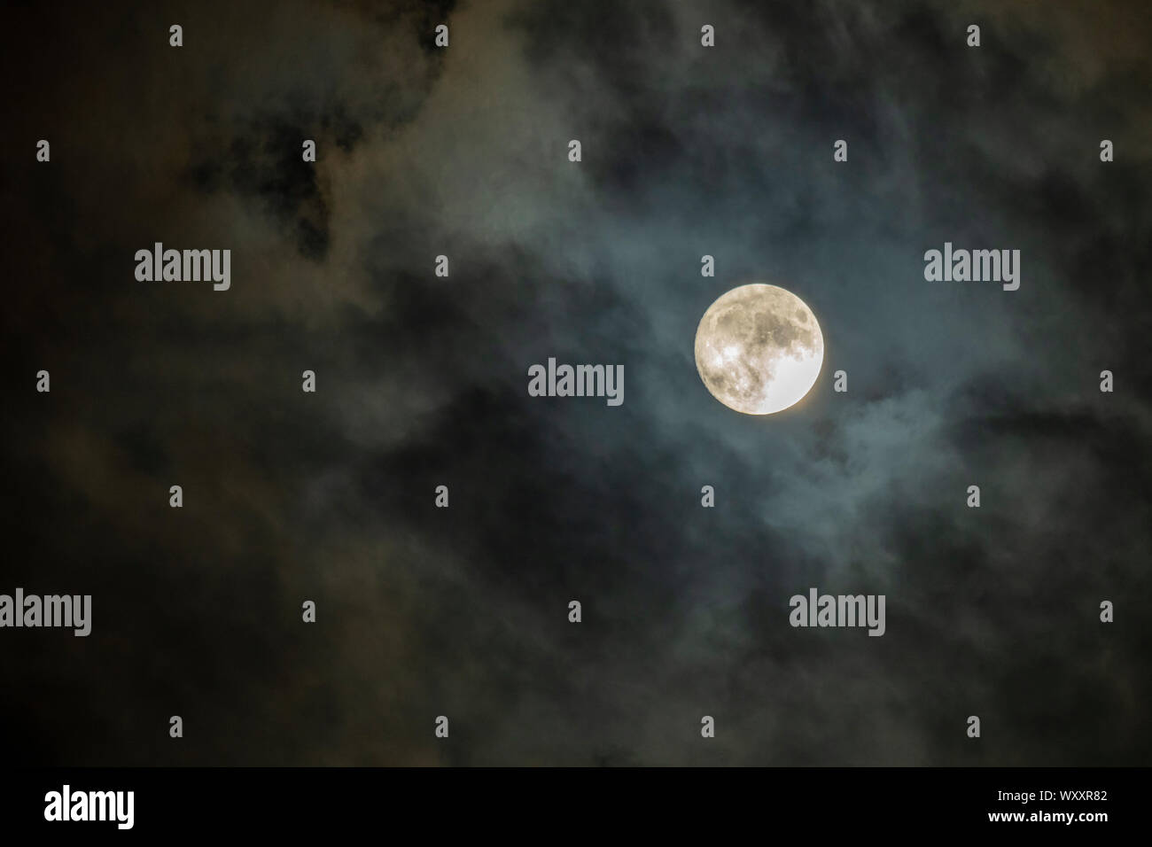 Full moon in cloudy night sky Stock Photo