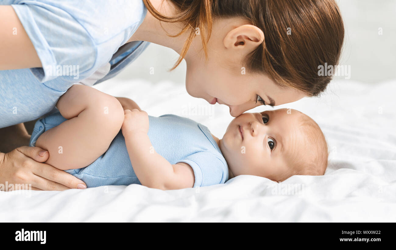 Young mother looking at her newborn baby with adoration Stock Photo
